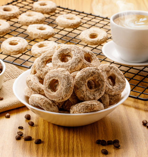 Pote com biscoito calda sabor cappuccino, ao lado de xícara de café