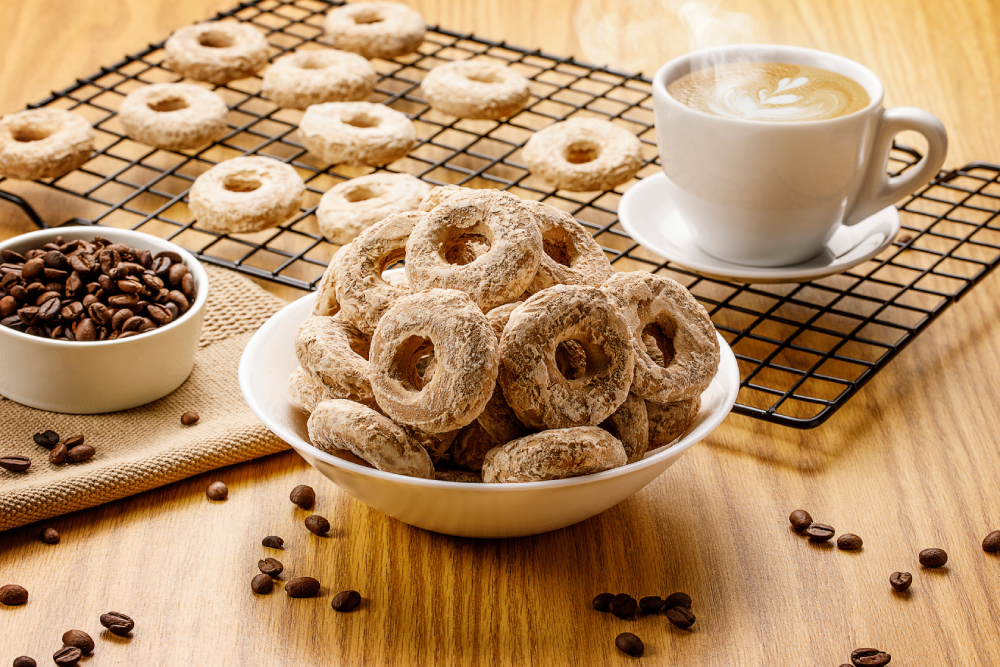 Pote com biscoito calda sabor cappuccino, ao lado de xícara de café