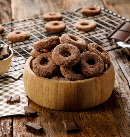 Pote com biscoito calda sabor chocolate, sobre fundo desfocado.