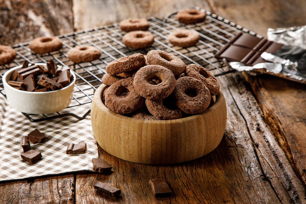 Pote com biscoito calda sabor chocolate, sobre fundo desfocado.
