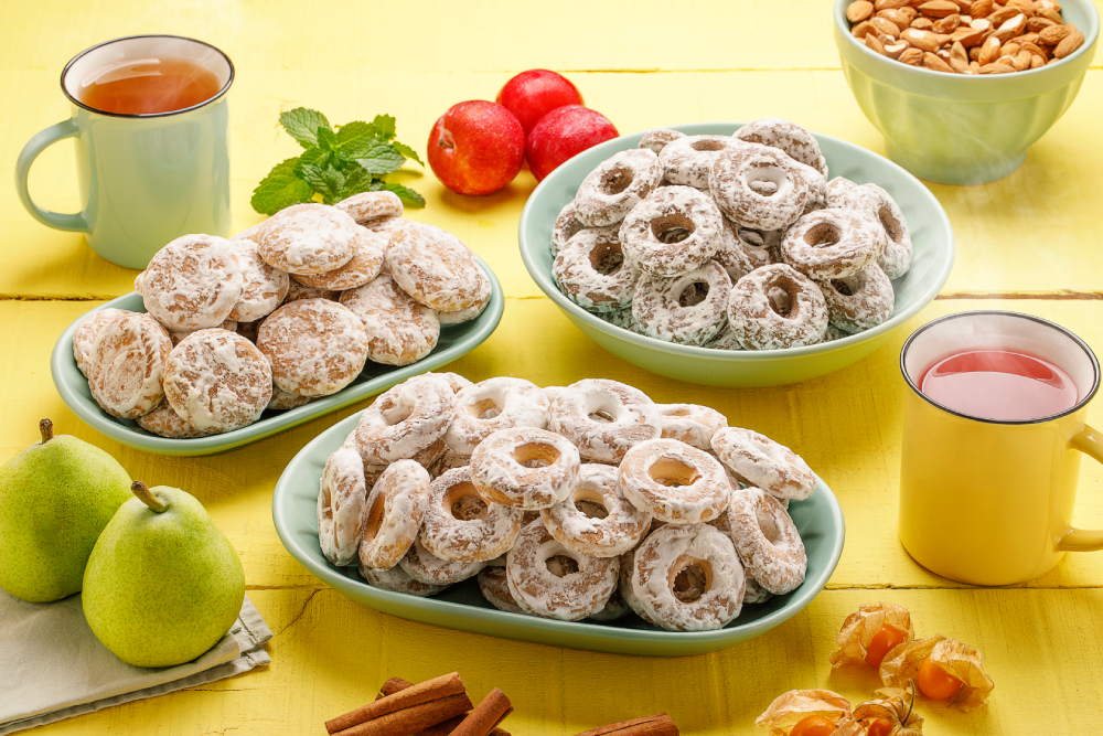Pratos com biscoitos rosca de calda, dispostos ao lado de xícaras de chá