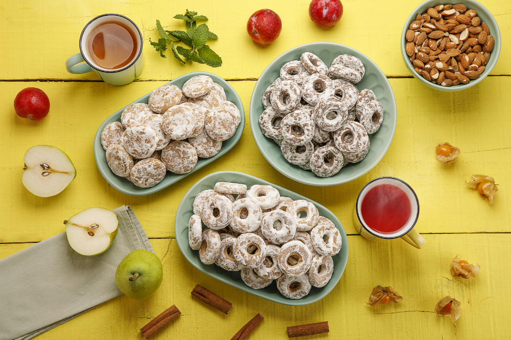 Pratos com biscoitos de pão de mel, dispostos ao lado de xícaras de chá.