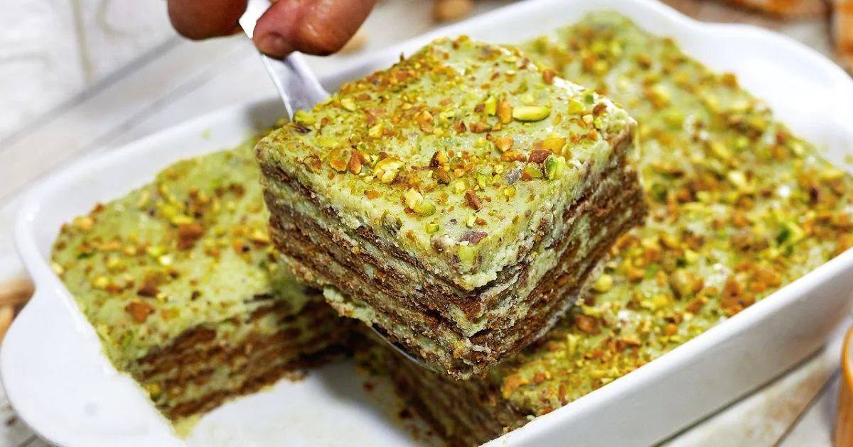 Travessa com pavê de pistache em camadas, preparado com biscoito champanhe, creme e cobertura de pistache triturado.